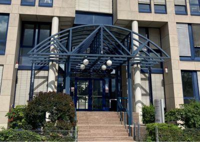 Zentrum für Weiterbildung – Standort Mannheim Eingangsbereich eines modernen Bürogebäudes mit Glasdach und Treppenaufgang – Standort Mannheim des Zentrums für Weiterbildung.