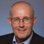 Sven Glaser – Zentrum für Weiterbildung Sven Glaser - Porträt eines Mannes mit kurz geschnittenen Haaren, Brille und Hemd mit Sakko, der direkt in die Kamera lächelt.