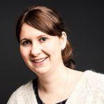 Jessica Pede – Zentrum für Weiterbildung Jessica Pede - Porträt einer lächelnden Frau mit mittellangen braunen Haaren, hellem Strickpullover und dunklem Hintergrund.