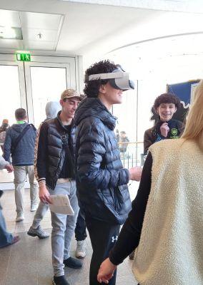 Jugendlicher mit Virtual-Reality-Brille beim Ausprobieren eines digitalen Angebots auf der Messe.