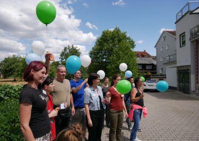 Besucherinnen und Besucher stehen mit bunten Luftballons vor dem Standort des Zentrums für Weiterbildung in Fürth.