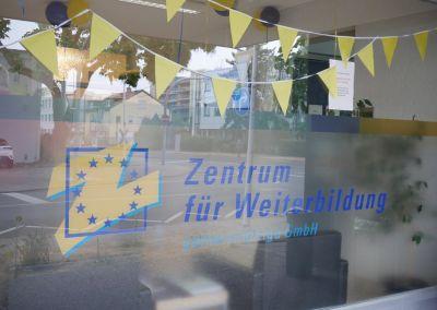 Besucherinnen und Besucher posieren mit Verkleidungsaccessoires in der Fotobox beim Tag der offenen Tür des Zentrums für Weiterbildung in Fürth.