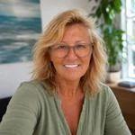 Porträt von Beyhan Dogan Blonde Frau mit dunkler Brille lächelt freundlich in die Kamera. Sie trägt ein grünes Oberteil und sieht professionell aus.